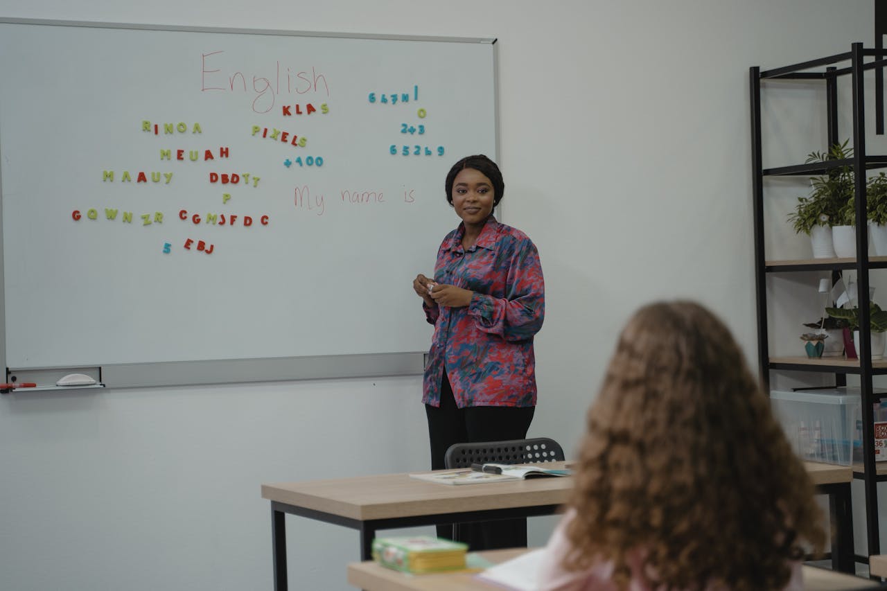 services-03 A teacher explaining English concepts to a student in a classroom setting with a whiteboard.