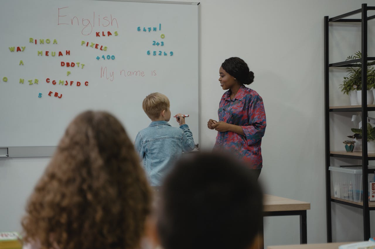 services-04 A teacher engages students in an interactive English lesson using a whiteboard and magnetic letters.